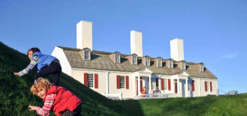 Children playing on a hill with Fort Anne in the background