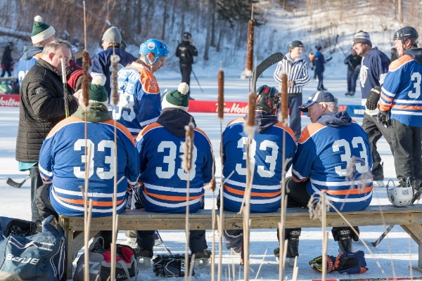 Hockey players on a bench on an outdoor pond