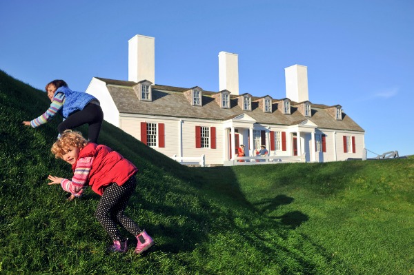 Children playing on a hill with Fort Anne in the background